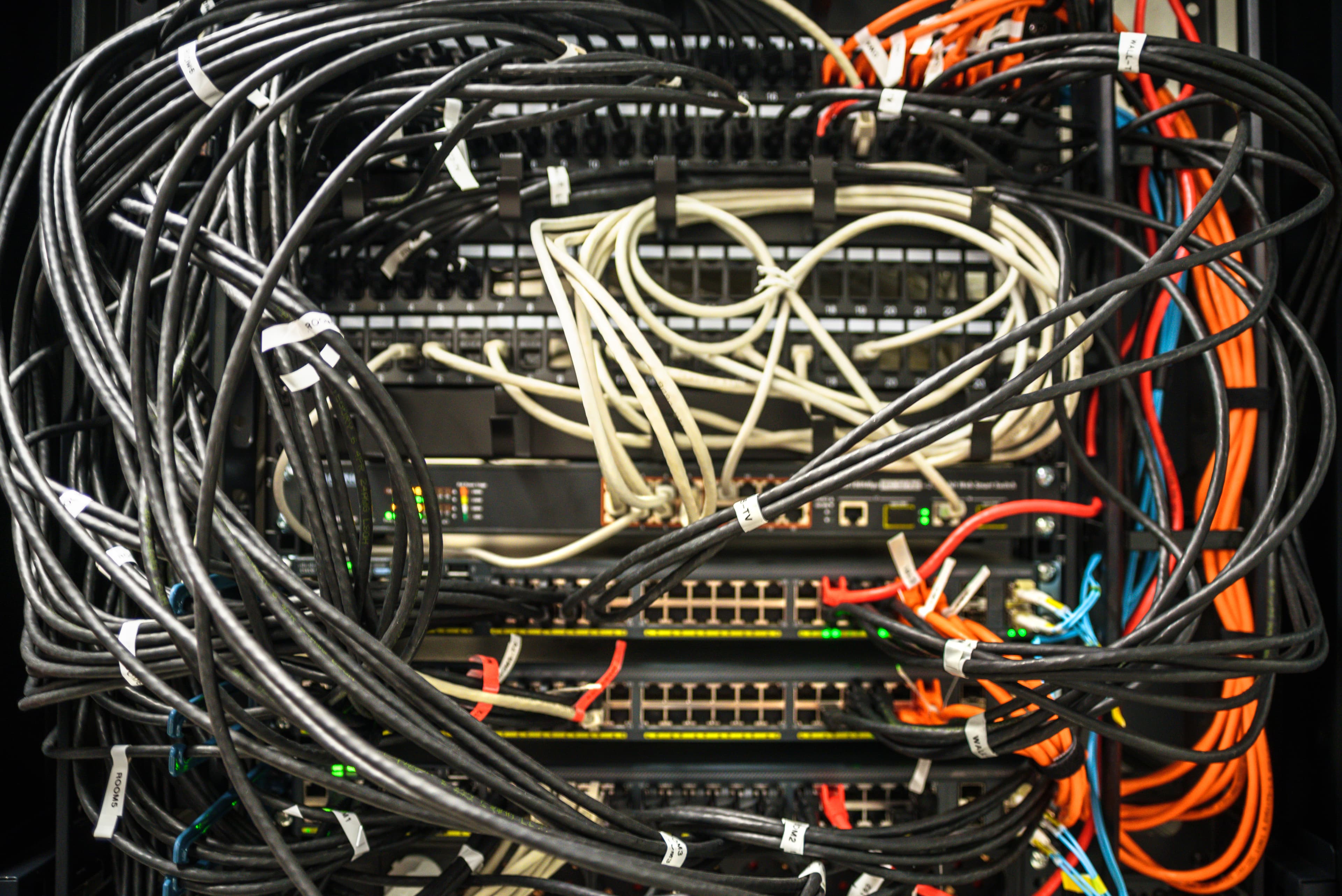 Rack de red tradicional desordenado, sin etiquetar, con cableado suelto